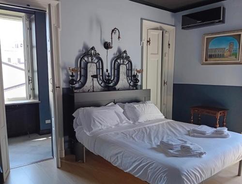 um quarto com uma cama grande e lençóis brancos em La Meridiana d'Alba em Alba