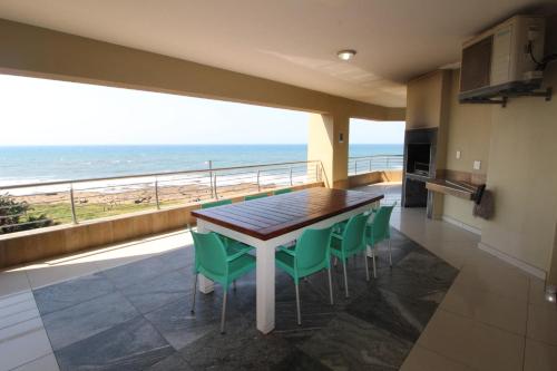 a dining room with a table and chairs and the ocean at Saints View Resort Unit 14 in Uvongo Beach