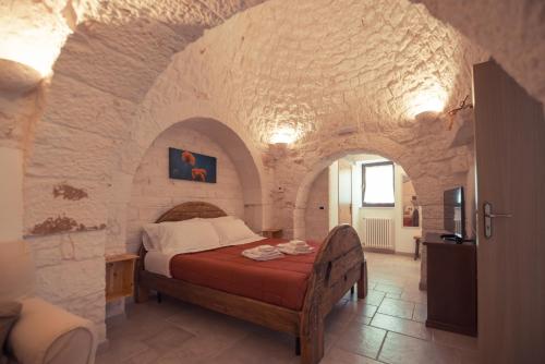 a bedroom with a bed in a stone wall at I Trulli Di Badi in Locorotondo