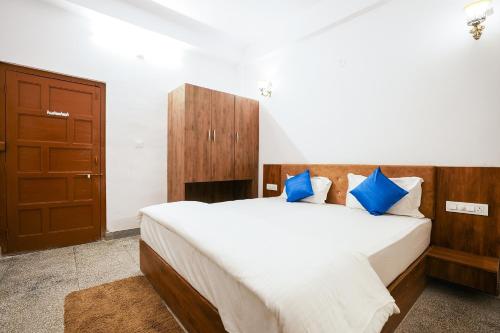 um quarto com uma cama grande e almofadas azuis em Devdarshan Hotel & Restaurant em Udaipur