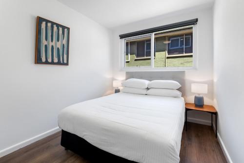 una camera con un letto bianco e una finestra di 1-Bed in Vibrant St Kilda Perfect for a Staycation a Melbourne