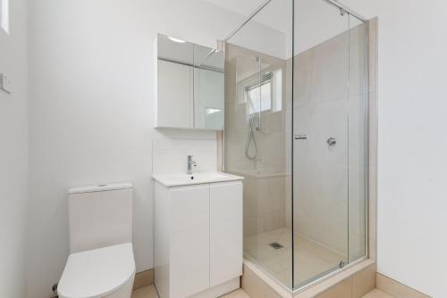 bagno bianco con doccia e lavandino di 1-Bed in Vibrant St Kilda Perfect for a Staycation a Melbourne