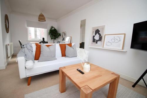een woonkamer met een witte bank en een salontafel bij Alicia's House by Tŷ SA in Newport