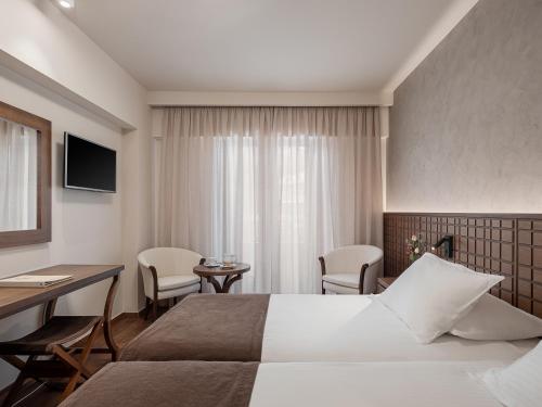 a hotel room with a bed and a table and chairs at Civitel Akali Hotel in Chania Town