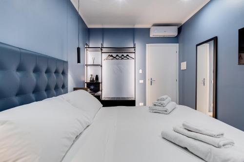 a bedroom with a white bed with blue walls at LISA SUITE in Rome