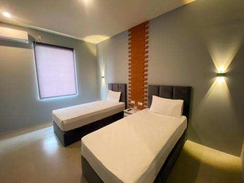 a small room with two beds and a window at Swiss-Belexpress Rest Area KM 164, Cipali in Majalengka