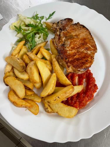 a plate of food with meat and french fries at Penzion U Šlechtů in Sněžné
