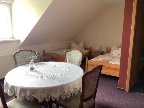 a room with a table and chairs and a bedroom at Pension Scherzer in Ohorn