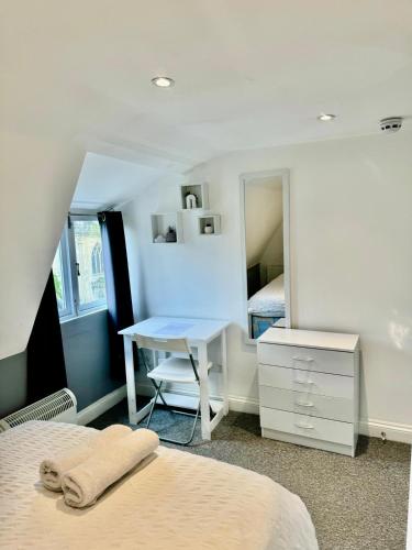 een slaapkamer met 2 bedden, een bureau en een spiegel bij Comfortable City Centre Room in Bristol