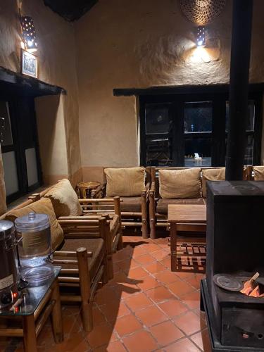 a living room with couches and tables and a tv at Prakriti Resort and Organic Farm Pvt. Ltd. in Burhānilkantha