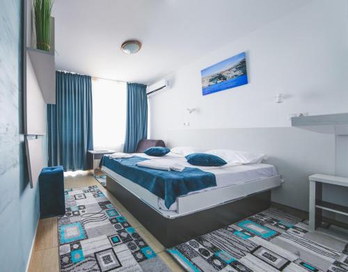 a bedroom with a bed with blue sheets and a rug at Hotel Carmen Azzuro in Venus