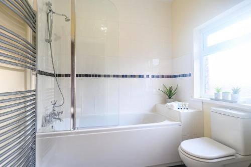 uma casa de banho branca com uma banheira e um WC em Beechwood House by Tŷ SA - ICC & Celtic Manor em Newport