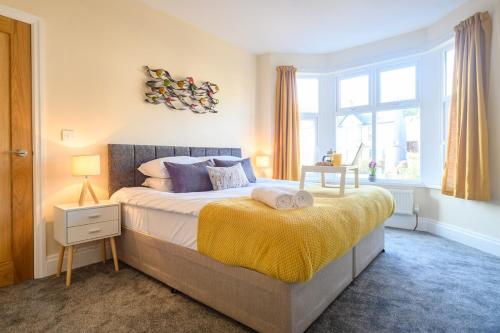 um quarto com uma cama com um cobertor amarelo em Beechwood House by Tŷ SA - ICC & Celtic Manor em Newport