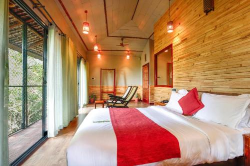 a bedroom with a large bed in a room with wooden walls at Vythiri Resort in Vythiri
