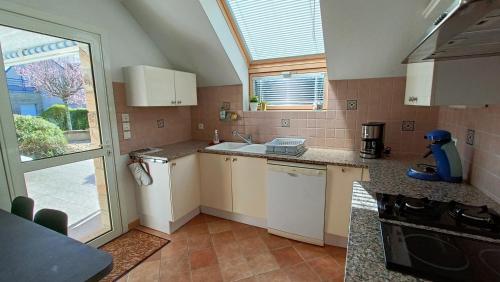 une petite cuisine avec un évier et une fenêtre dans l'établissement Ref 089 Maison standing avec jardin et internet pour dix, à Arzon