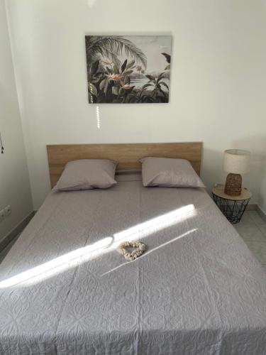 a bed in a bedroom with a picture on the wall at Appartement des Ponts Bleus in Martigues