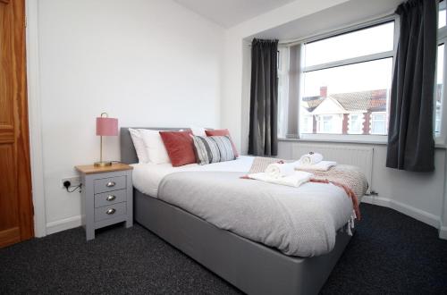 um quarto com uma cama e uma janela em Bellevue by Tŷ SA - Modern 3 bed in Newport em Newport