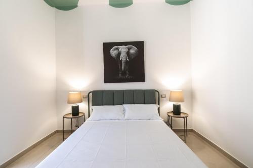 een slaapkamer met een groot wit bed met 2 lampen bij Il Viccio Apartment in Palo del Colle