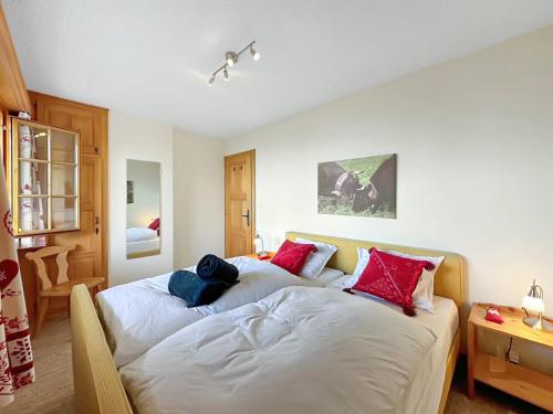 a bedroom with two beds with red and blue pillows at Chalet Jaliver - 4 Valleys - Swiss Alps in Nendaz