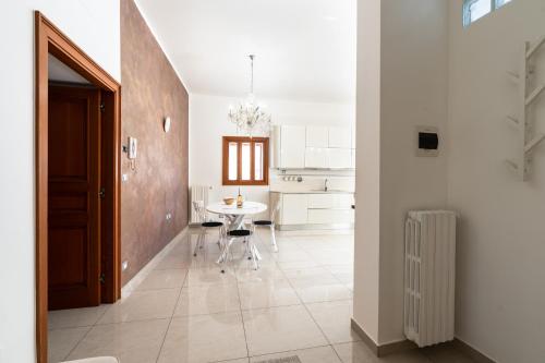 een witte keuken met een tafel en een eetkamer bij Il Viccio Apartment in Palo del Colle