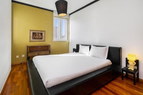 Un dormitorio con una gran cama blanca con ventana. en Lisbon Riverview Apartment by Premium Lisbon Stays, en Lisboa