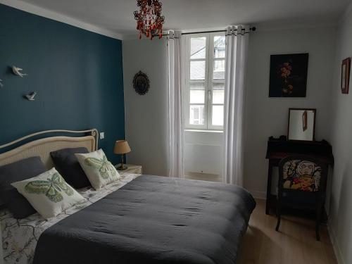 Schlafzimmer mit einem Bett mit blauen Wänden und einem Fenster in der Unterkunft L'auseth in Oloron-Sainte-Marie