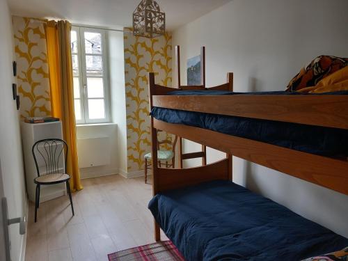 Zimmer mit 2 Etagenbetten und einem Stuhl in der Unterkunft L'auseth in Oloron-Sainte-Marie