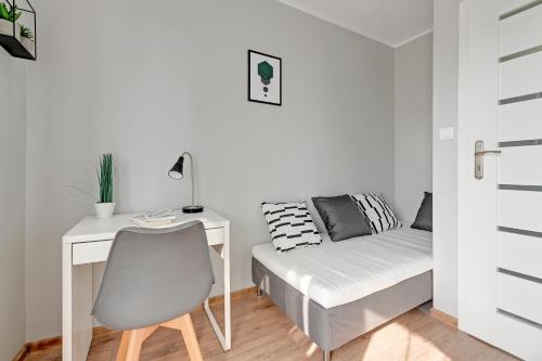um quarto com uma secretária, uma cama e uma cadeira em Pokoje Gdańsk Żabianka - Gdyńska em Gdansk