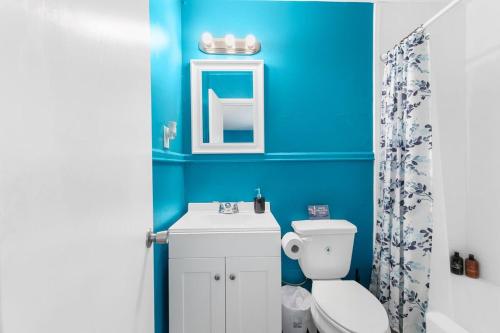 a blue bathroom with a toilet and a sink at The Bricks - Apt 6 in Birmingham