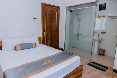 um quarto com uma cama e uma cabina de duche em vidro em Hotel Hoàng My Phú Yên em Liên Trì (3)