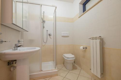 ein Bad mit einer Dusche, einem Waschbecken und einem WC in der Unterkunft Green Bay C12 - Pineto Vacanza in Pineto