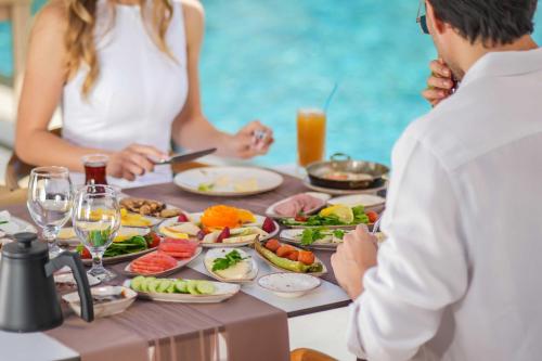 a group of people sitting around a table with food at Ramitos Hotel in Turunc