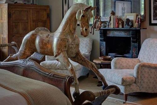 a wooden horse standing on a chair in a living room at The Rudloe Arms Hotel Marco Pierre White Nr Bath in Corsham