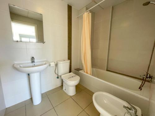 Baño blanco con lavabo y aseo en Apartamentos Benicarló Lowcost 3000, en Benicarló