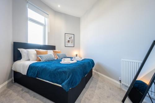 1 dormitorio con 1 cama grande con manta azul en Brynglas House by Tŷ SA en Newport