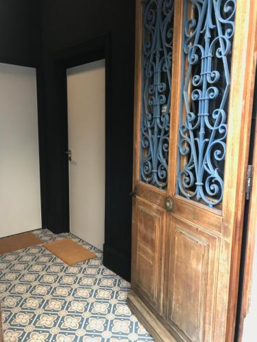 - une porte ouverte en bois dans une chambre dotée de carrelage dans l'établissement Joli appartement en Maison de Ville, à Valréas