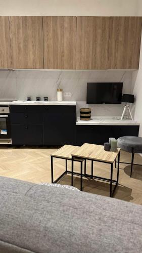 un salon avec une table et une cuisine dans l'établissement Joli appartement en Maison de Ville, à Valréas