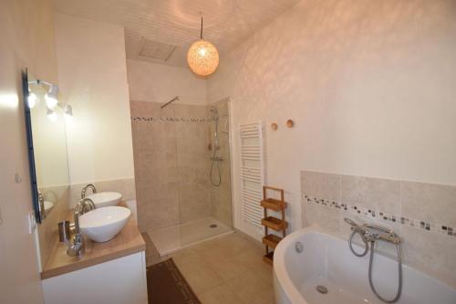 a bathroom with a tub and a sink and a shower at L'étape de Loudun in Loudun
