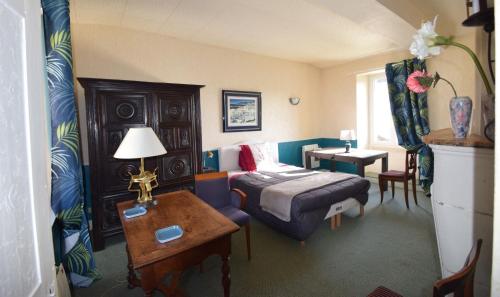 a bedroom with a bed and a desk and a table at L'étape de Loudun in Loudun