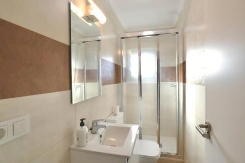 uma casa de banho com um chuveiro, um WC e um lavatório. em Notel Club - Vistalmar apartamento en Cueto em Santander