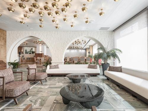 a living room with couches and a table and chairs at Civitel Akali Hotel in Chania Town
