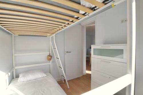 um pequeno quarto com um beliche e uma escada em Notel Club - Vistalmar apartamento en Cueto em Santander