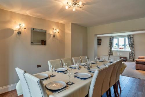a dining room with a long table and chairs at Finest Retreats - Stone Bow Farmhouse in Weston-super-Mare