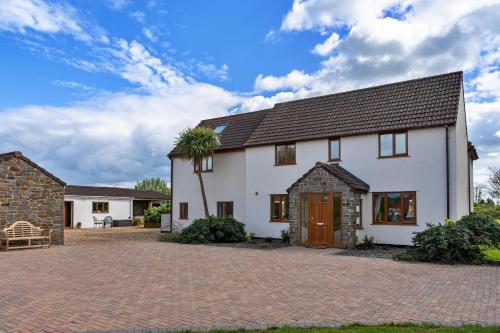 a white house with a palm tree in the driveway at Finest Retreats - Stone Bow Farmhouse in Weston-super-Mare