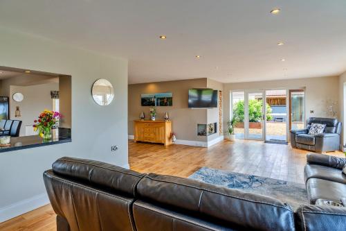 sala de estar con sofá de cuero marrón en Finest Retreats - Stone Bow Farmhouse, en Weston-super-Mare
