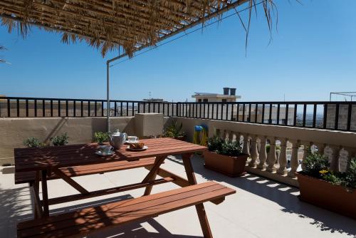 a table and benches on a balcony with a view of the ocean at Villa Sunview in Rabat