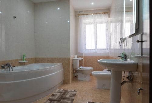 a bathroom with a tub and a toilet and a sink at Villa Sunview in Rabat