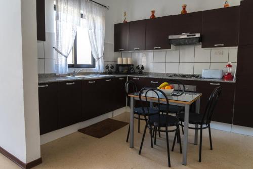a kitchen with black cabinets and a table with chairs at Villa Sunview in Rabat