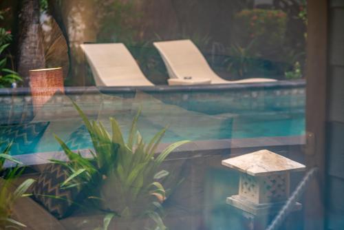 a pool with two loungers and a swimming pool at Manta Dive Gili Trawangan Resort in Gili Trawangan