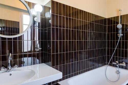 een badkamer met een wastafel en een spiegel bij The Originals Access, Hôtel Figeac in Figeac
